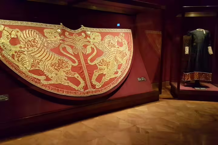 Intricately embroidered imperial robe and regal attire displayed at the Imperial Treasury tour in Vienna.