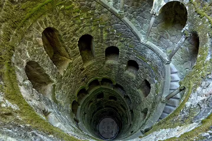 Mysterious spiral staircase of the Initiation Well at Quinta da Regaleira in Sintra, Portugal, featured on a full-day tour from Lisbon.