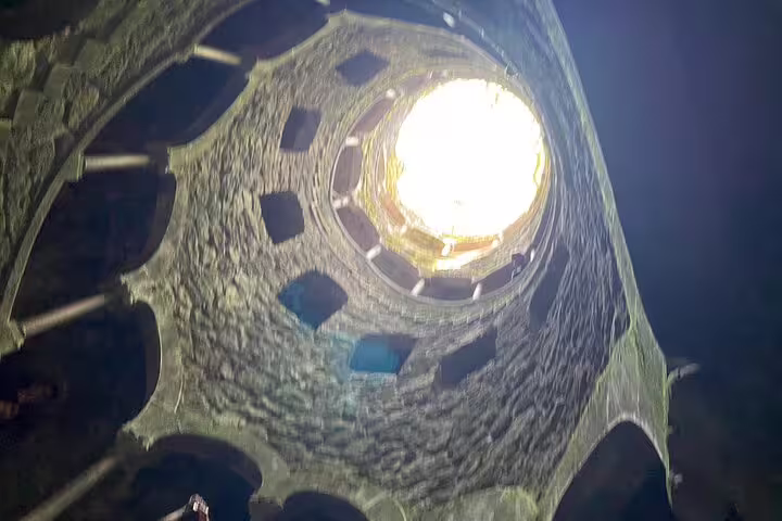 Dramatic upward view of the Initiation Well at Quinta da Regaleira, a highlight on the Sintra & Cascais tour.