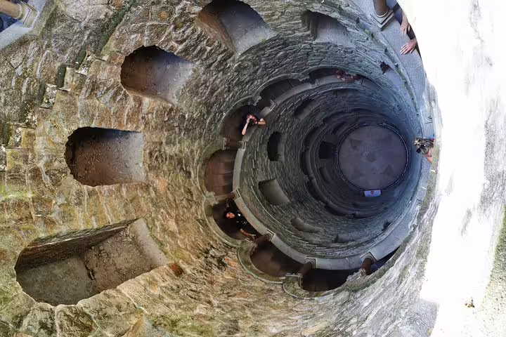 View of the enchanting Initiation Well in Sintra, Portugal, showcasing its mystical spiral staircase on a private tour.