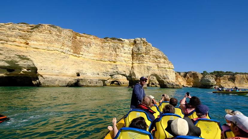 Visitors enjoy a scenic boat ride past Algarve's dramatic cliffs on the Insonia Private tour under clear blue skies.