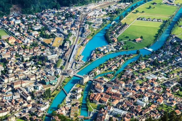 Aerial view of Interlaken showcasing the vibrant town and turquoise rivers winding through the landscape.