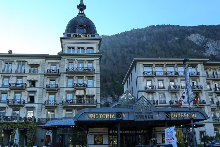 Historic hotel facade in Interlaken surrounded by Swiss Alps, featured in Blausee Lake and Interlaken tour.