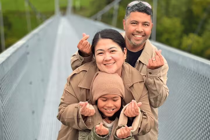 Happy family posing on a scenic bridge during a private tour in Interlaken, capturing Crash Landing on You vibes.