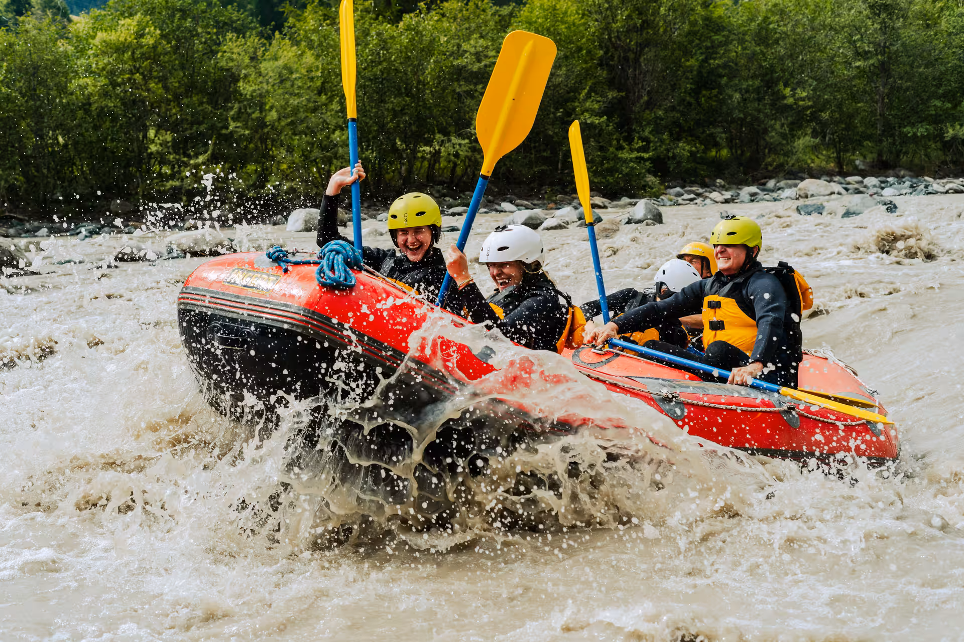 Excited rafters navigate challenging Interlaken rapids, showcasing teamwork and adventure spirit.