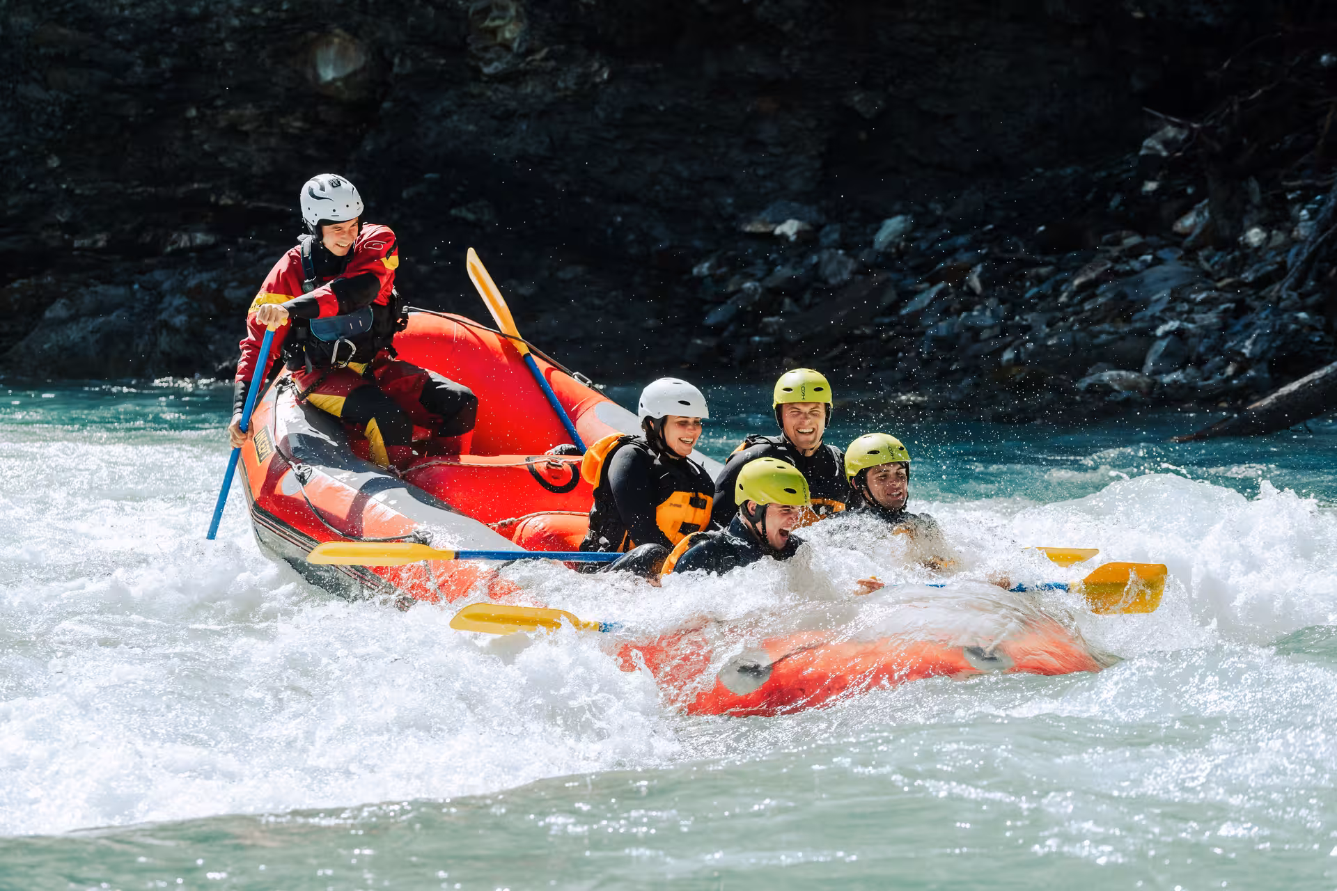 Group navigating thrilling rapids while rafting in Interlaken, showcasing adventure and teamwork on crystal-clear waters.