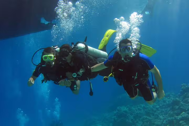 Guided intro scuba diving and snorkeling day trip with divers and bubbles over vibrant coral reef in crystal-clear water
