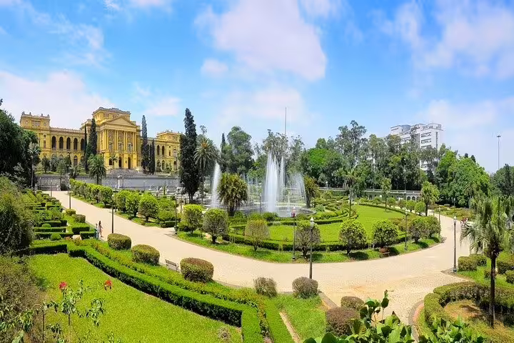 Panoramic view of Ipiranga Museum's lush gardens with fountains, capturing the neoclassical architecture and serene pathways.