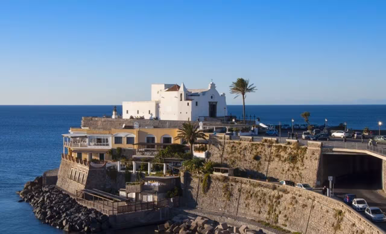 Ischia Ponte coastline with white church and sea views, explored on Naples to Ischia round-trip hydrofoil