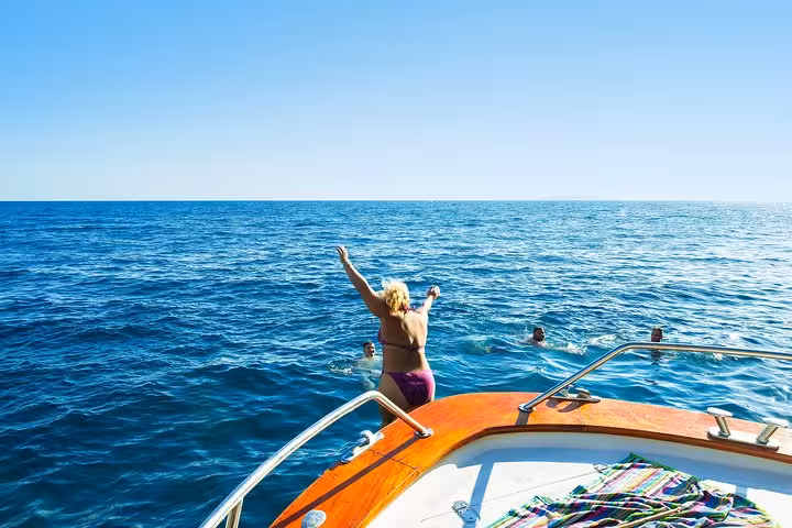 Tourists enjoying a refreshing swim from a boat on the Ischia and Procida small-group tour from Sorrento.