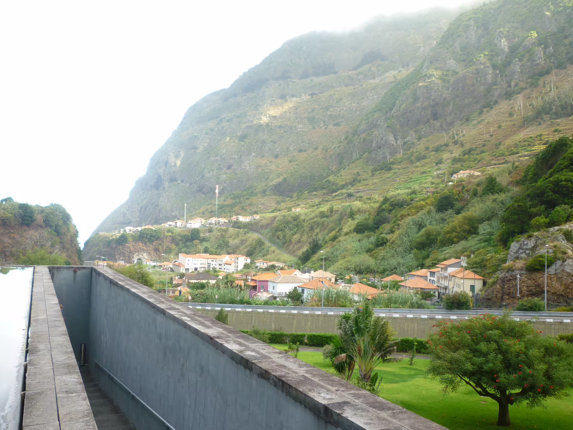 Scenic view of mountains, quaint village, and vibrant greenery on an island exploration tour.