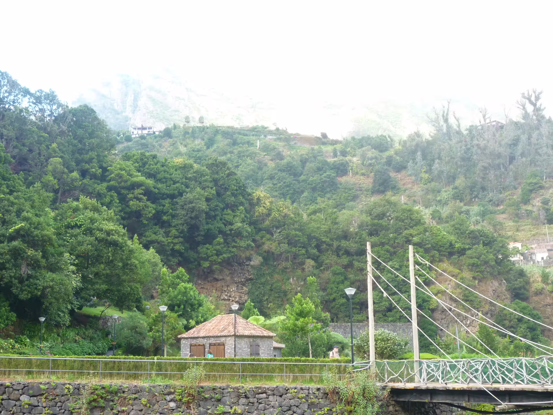 Charming stone house and suspension bridge nestled in a verdant forest setting on the island adventure tour.