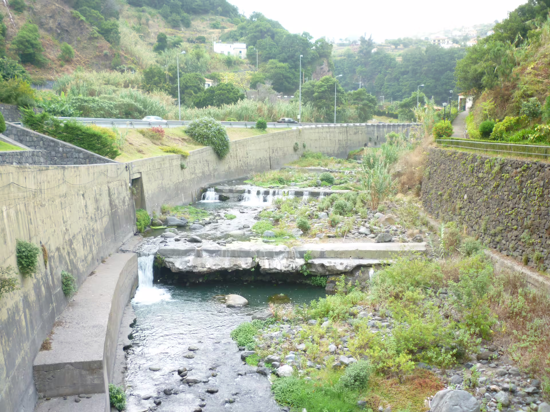 Scenic river view with cascading waterfalls surrounded by lush greenery on a two-day island tour.