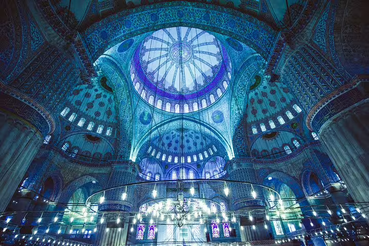 Stunning interior of Istanbul's Blue Mosque featuring intricate blue tilework and grand chandeliers, highlight of private tour.