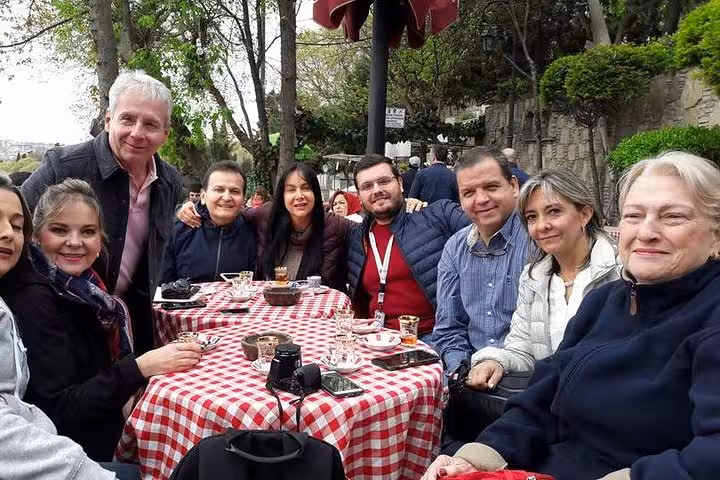 Group enjoying lunch at a scenic Istanbul cafe during Asia-Europe Bosphorus full day tour with museum fees included