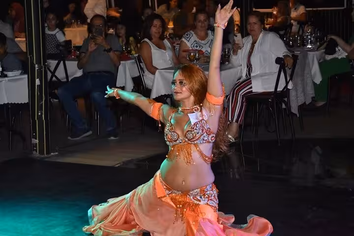 Belly dancer performs on Istanbul Bosphorus dinner cruise Turkish night, guests seated at private tables