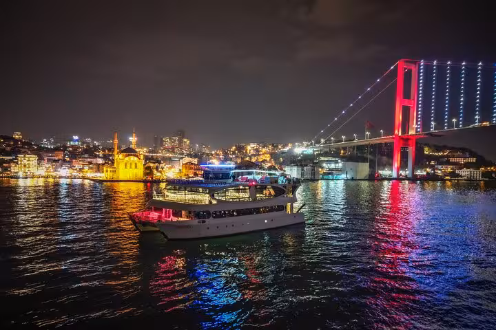 Istanbul Bosphorus dinner cruise yacht by 15 July Martyrs Bridge at night, Turkish night show onboard