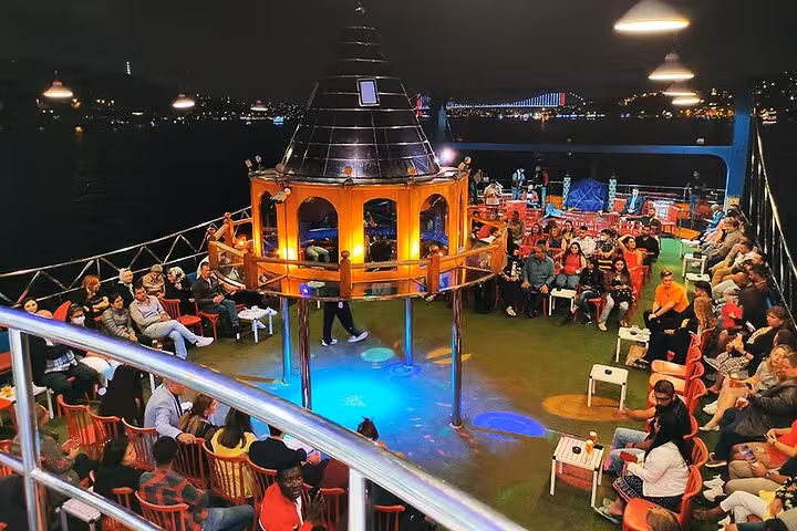 Open-air deck on Istanbul Bosphorus dinner cruise with private seating, live entertainment and night skyline views