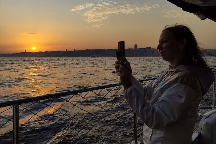 Traveler photographing the Bosphorus sunset from a luxury yacht in Istanbul during a wine sunset cruise