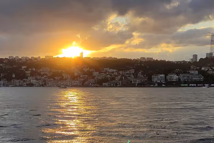 Golden sunset over Istanbul skyline from Bosphorus, seen on luxury yacht cruise with wine at dusk