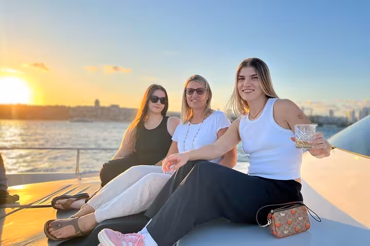Friends relaxing on a luxury yacht at sunset on the Bosphorus in Istanbul, enjoying wine and sea views