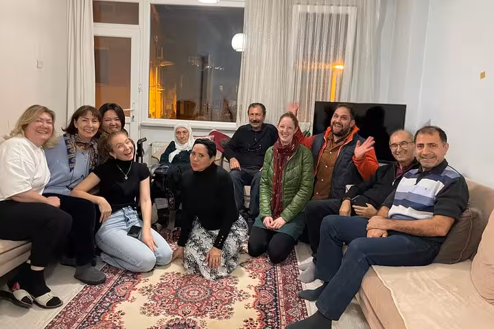 Travelers relax with an Istanbul family after dinner, experiencing authentic Turkish home hospitality and local culture