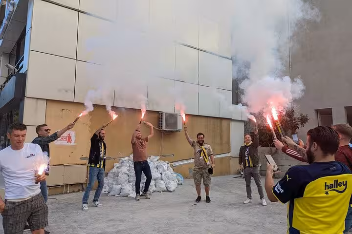 Fans with local guide lighting flares before Istanbul football meetup, pre-game atmosphere for join-a-game tour