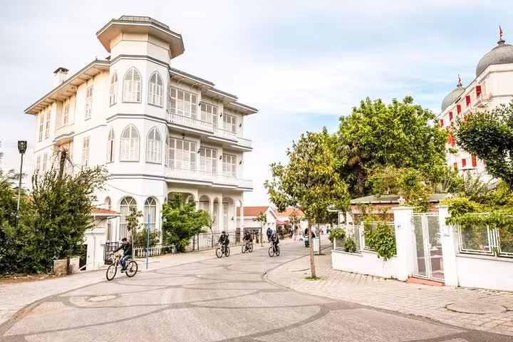Cyclists ride past historic mansions on Büyükada, a highlight of Istanbul Princes Islands tour to Heybeliada