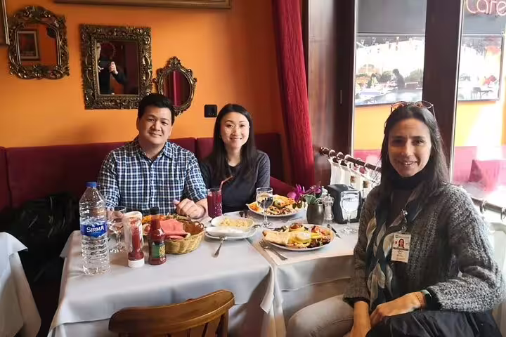 Tourists enjoying a traditional Turkish meal at a cozy Istanbul café during the SKIP-THE-LINE private tour from Galataport.