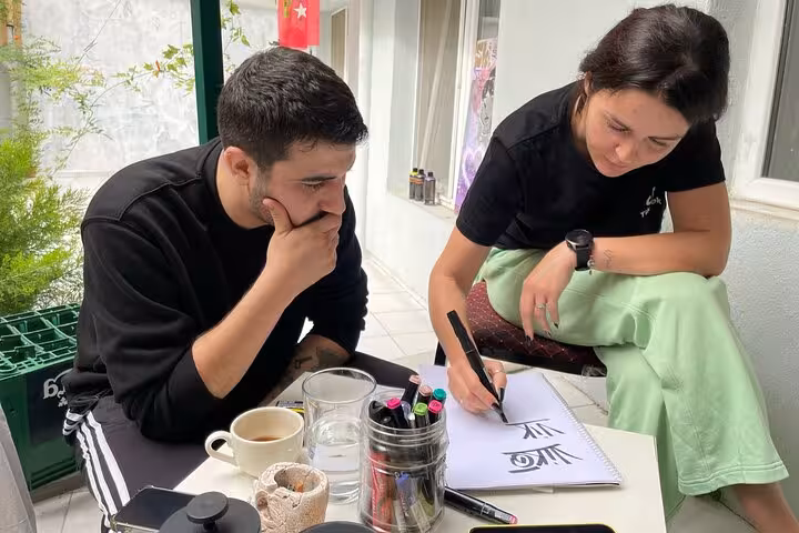 Local artists teaching sketching and graffiti tags at a cozy Istanbul home garden street art workshop