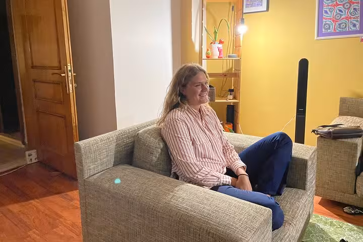 Traveler enjoying Istanbul Turkish tea tasting and networking session, seated in cozy living room Sip & Connect