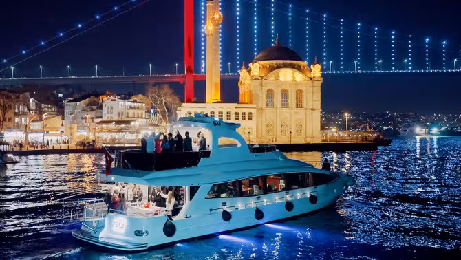 Istanbul waterfront at night with illuminated mosque and bridge