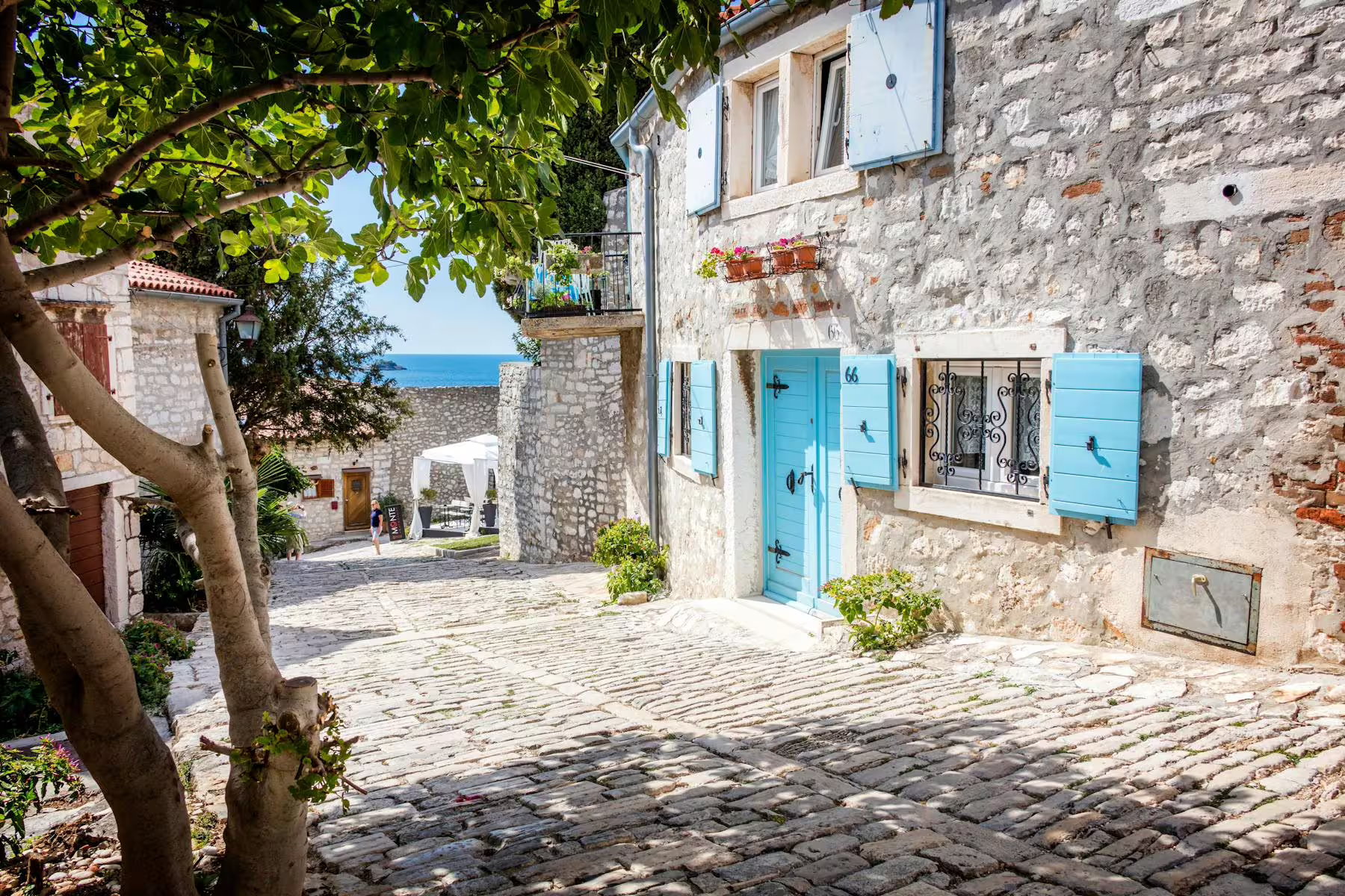 Seaside stone lane with blue shutters in Vrsar, featured on the Istrian Coast boat cruise with BBQ from Poreč
