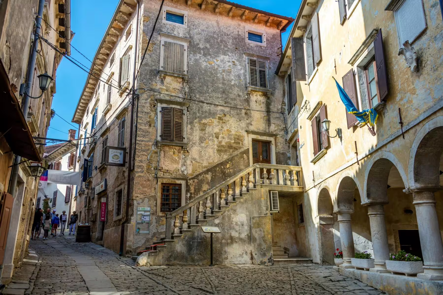 Cobblestone street in an Istrian hilltop village with historic stone houses, walking tour with tasting