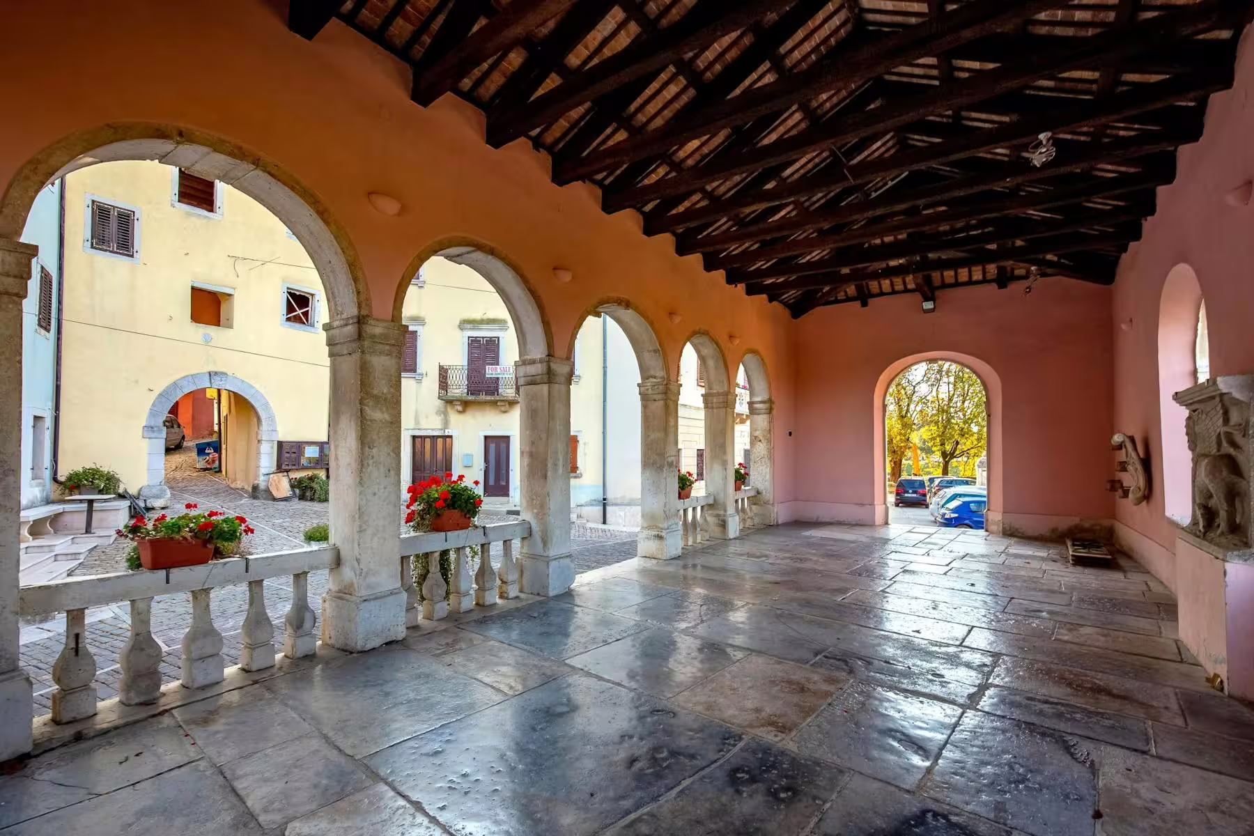 Arched stone loggia in an Istrian hilltop village square, a scenic stop on local tasting tour in Croatia