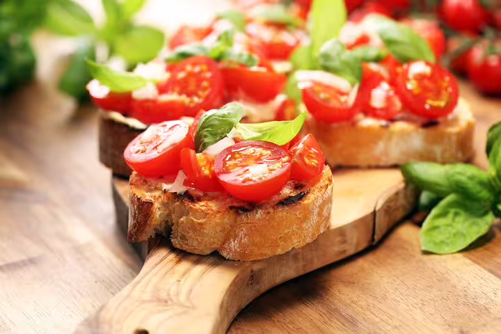 Fresh Italian bruschetta with cherry tomatoes and basil on a wooden board, perfect for an aperitivo tour near the Vatican.