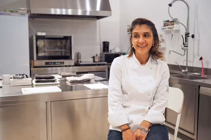 Smiling Italian chef in modern kitchen, ready to teach authentic Italian recipes in an engaging cooking class.