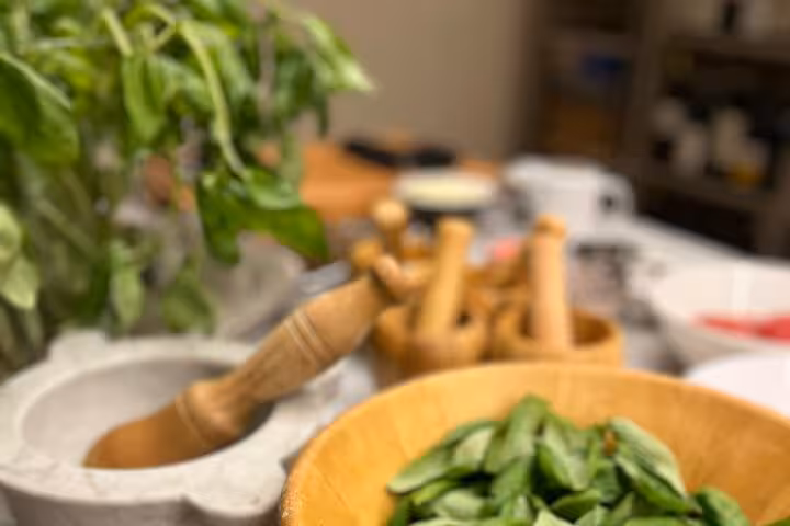 Fresh basil and a mortar with pestle ready for use in an authentic Italian cooking class focusing on traditional recipes.