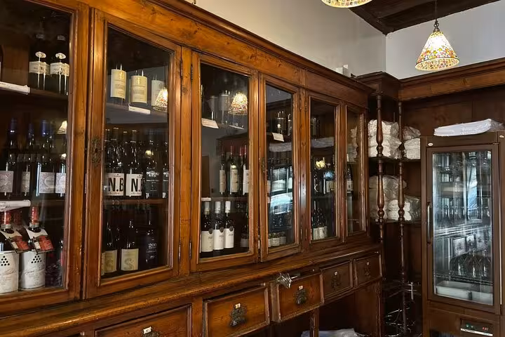 Elegant wooden shelves stocked with fine wines and culinary ingredients, enhancing the authentic Italian cooking class atmosphere.