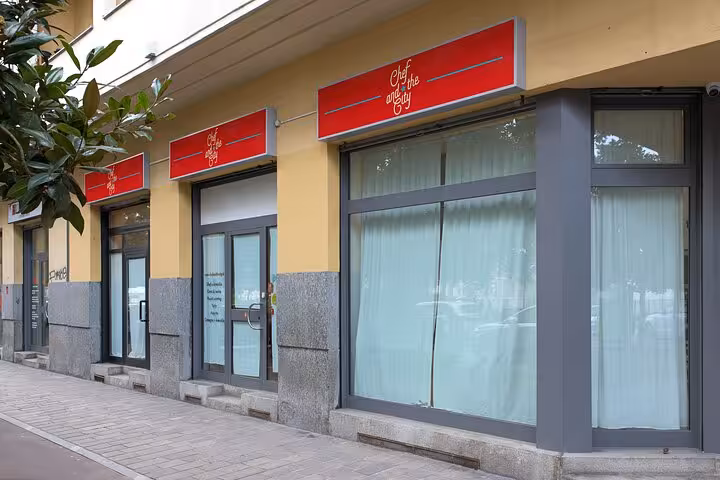 Charming Italian cooking school exterior with vibrant red signage, inviting guests to learn authentic recipes inside.