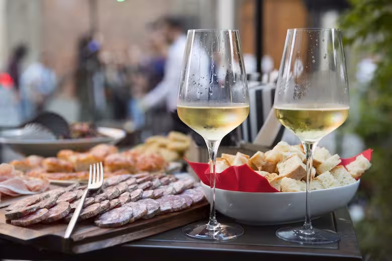 Two glasses of Italian Prosecco with salumi and bread on a table during a sparkling wine tasting experience