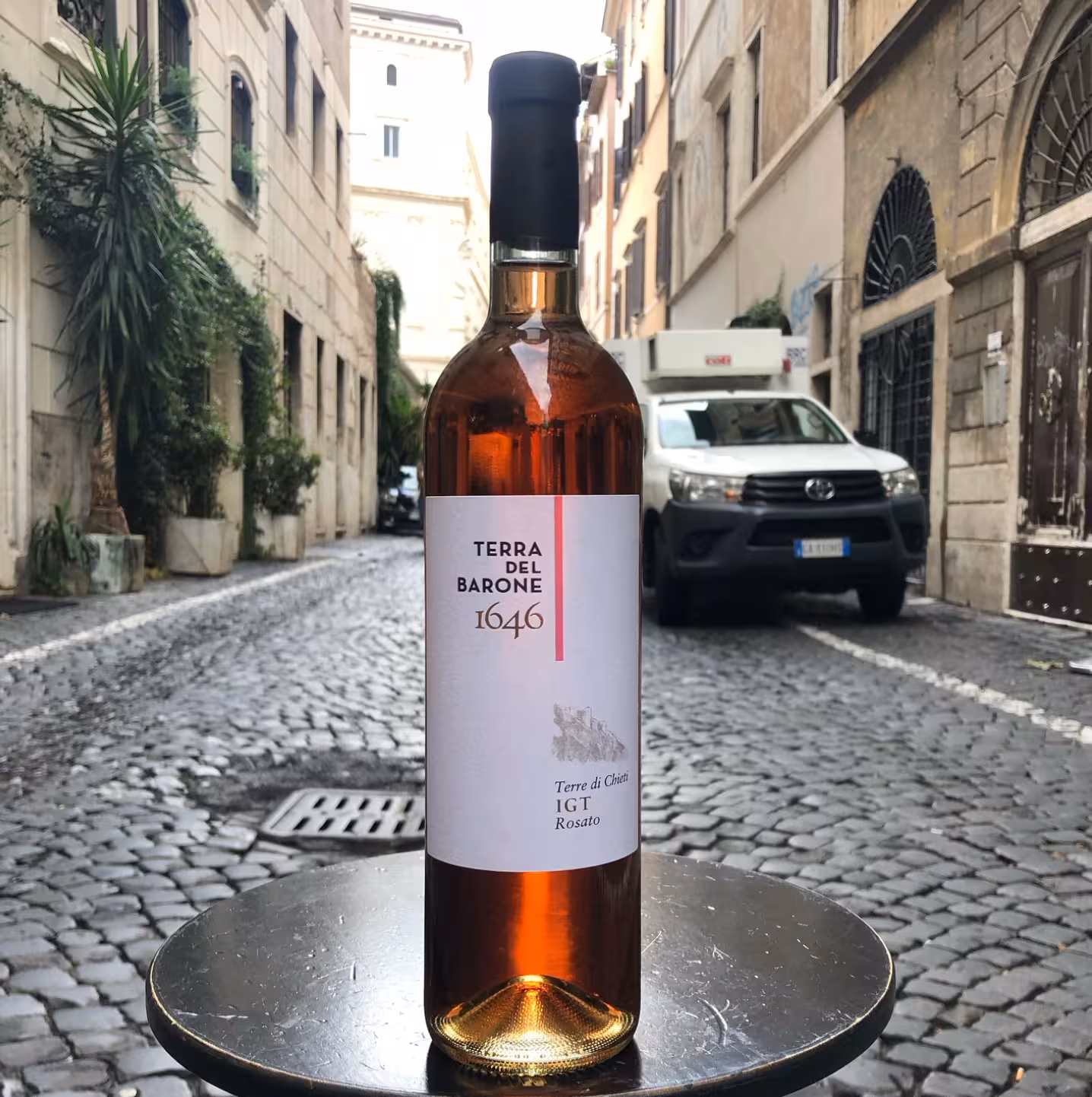Italian rosé bottle on a cobblestone Rome street, perfect for Wines & Vinyl vintage wine tasting tour