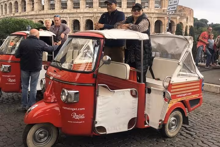 Tourists enjoy a James Bond Ape Calessino ride near the Colosseum, highlighting unique Rome sightseeing experiences.