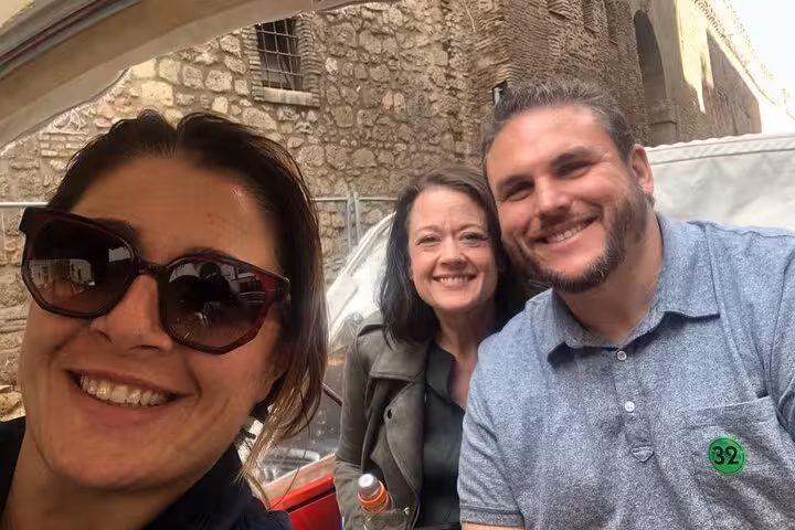Smiling travelers on a James Bond Ape Calessino tour, capturing the joy of exploring historic Rome alleyways.
