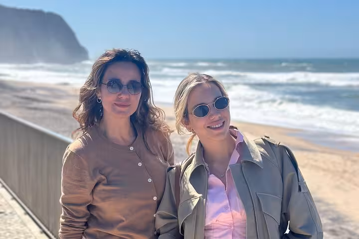 Two people enjoying the sunny Atlantic Coast view during a private tour in Sintra, Portugal.