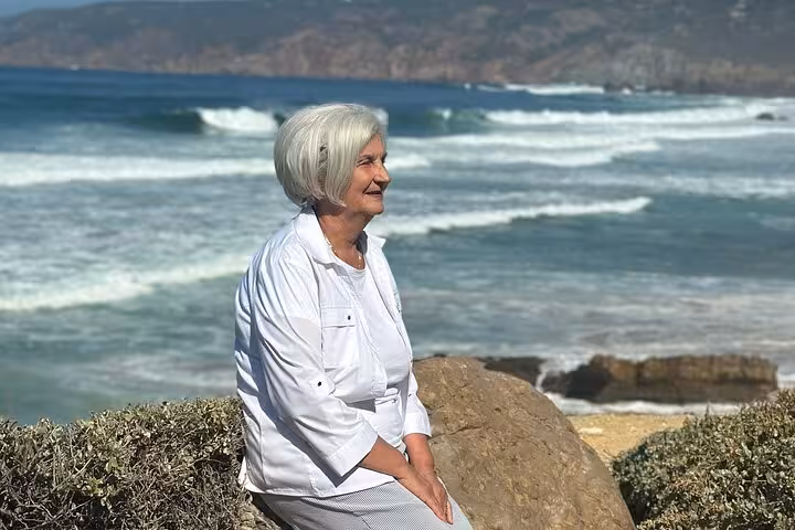 Woman enjoying the scenic Atlantic coastline views during a relaxing stop on a Sintra private tour.