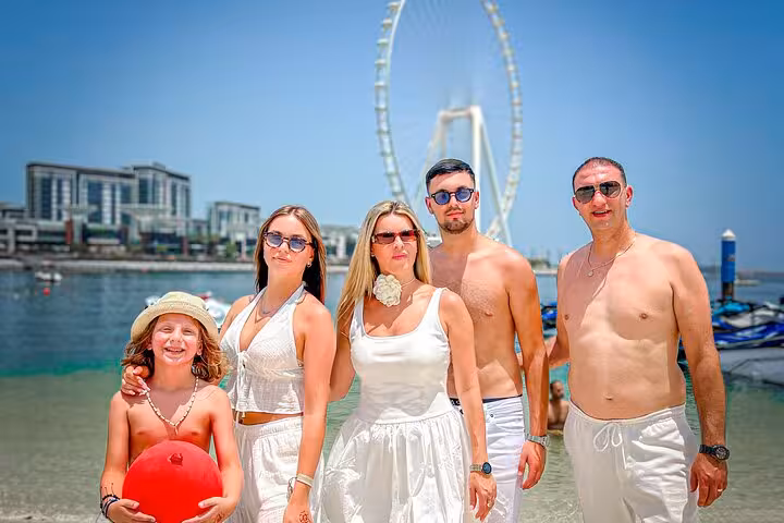 Family posing at JBR Beach with Ain Dubai Ferris wheel, capturing a perfect moment for the Instagram videography tour.