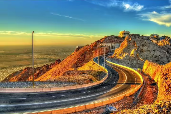 Scenic view of Jebel Hafeet mountain road during sunset on Al Ain private garden city tour with zoo ticket.