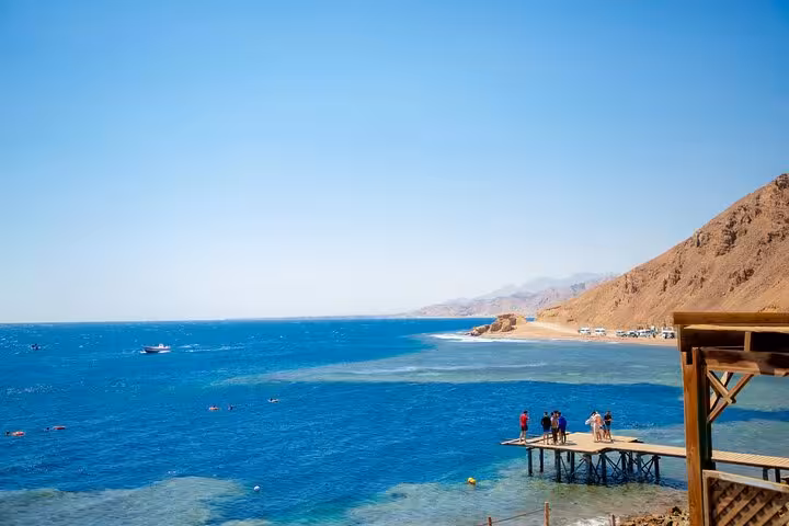 Red Sea viewpoint in Dahab with jetty and swimmers on Jeep tour from Sharm El-Sheikh to Canyon Salama