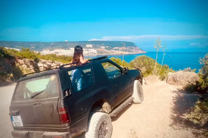 4X4 Jeep parked on scenic cliffside overlooking Arrábida coast, ideal for beach picnic tour in Sesimbra-Lisbon.